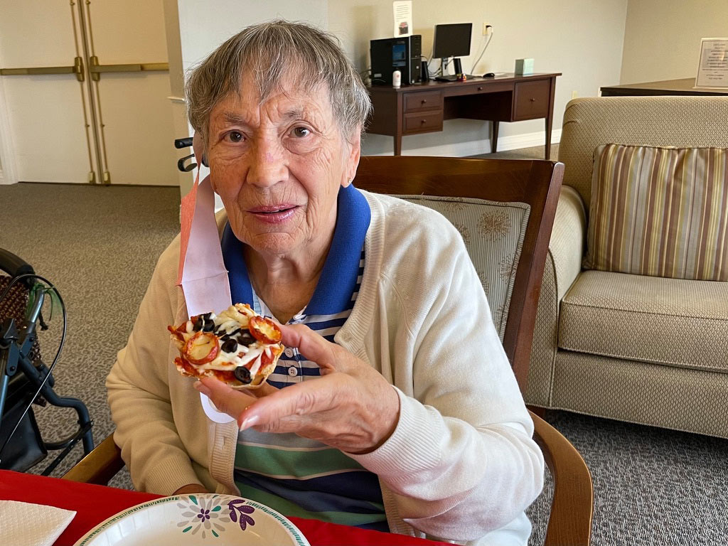 Pegasus Senior Living | Senior woman eating pizza