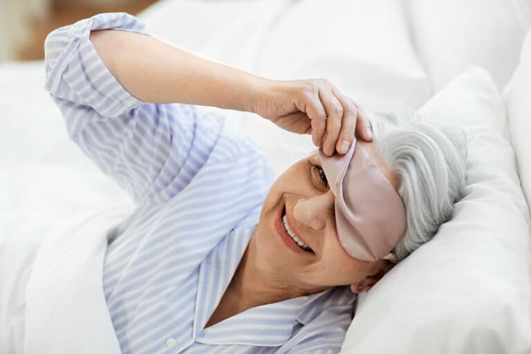 Broadway Mesa Village | Senior woman waking up smiling wearing eye mask
