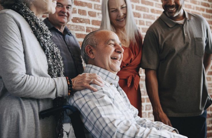 Cordata Court | Senior group surrounding man in wheelchair