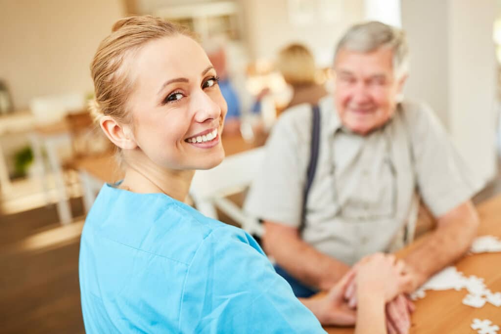 Pegasus Senior Living | Happy senior and caregiver doing a puzzle