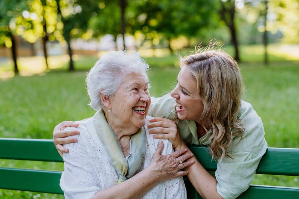 Creston Village | Adult granddaughter hugging grandmother on bench