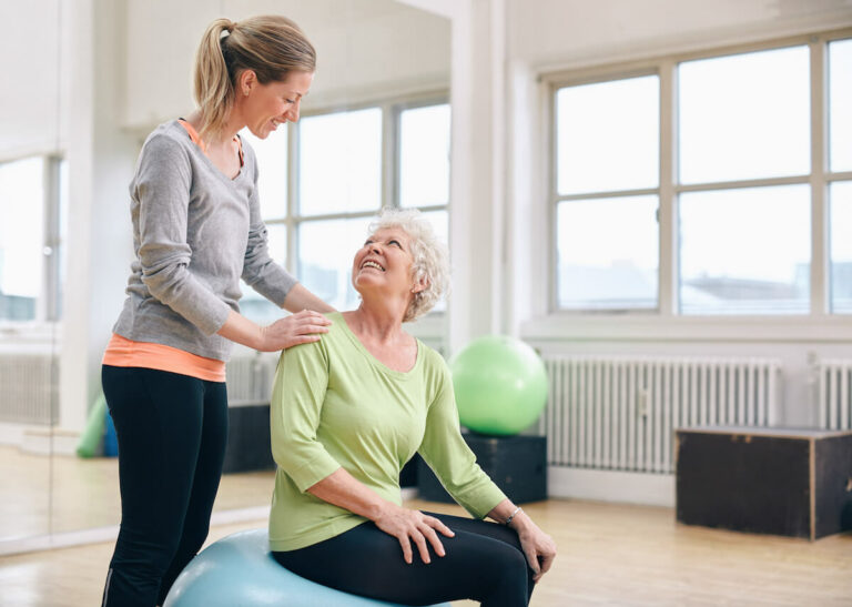 Pegasus Senior Living | Caregiver Assisting Senior with Exercise Activities