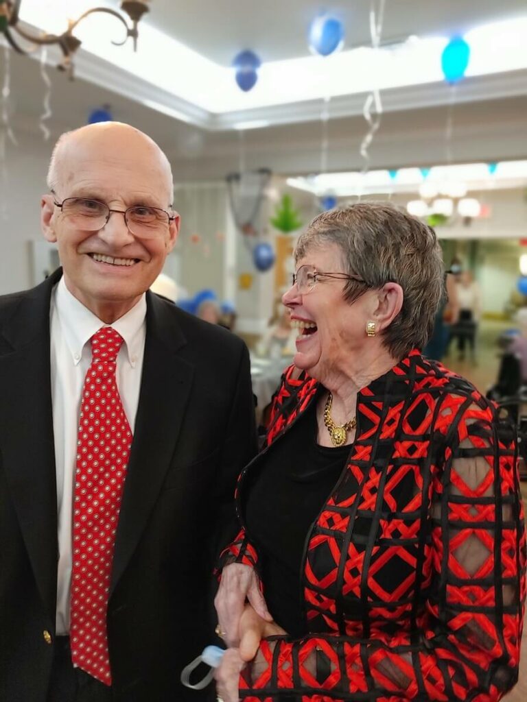 Pegasus Senior Living | Senior couple smiling and laughing at a community event