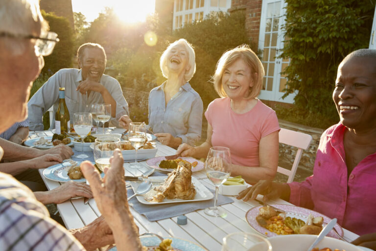 Dunwoody Place | Happy seniors gathered for dinner outside