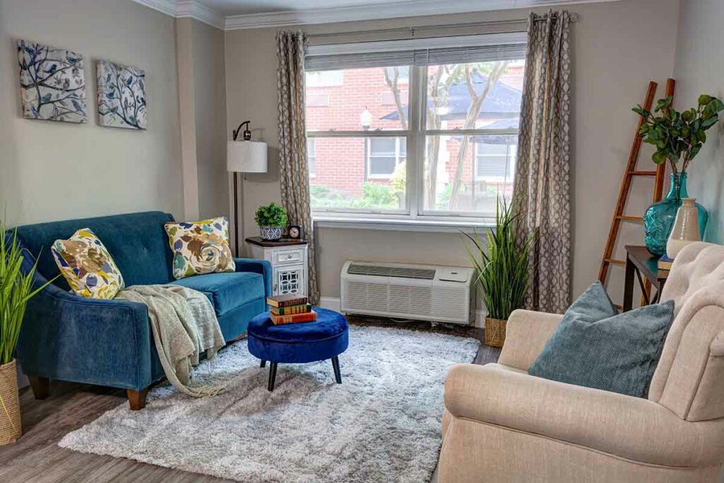 Dunwoody Place | Apartment living room with a couch and cushioned chair