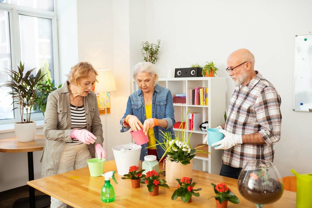 Dunwoody Place | Seniors potting plants in activity room
