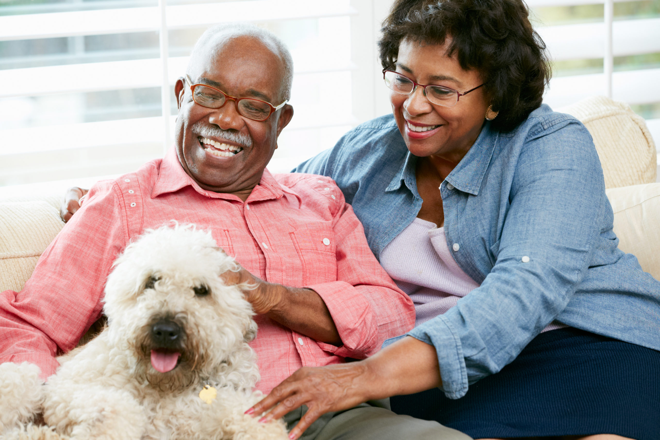 Elk Grove Park | Happy senior couple sitting on sofa with dog