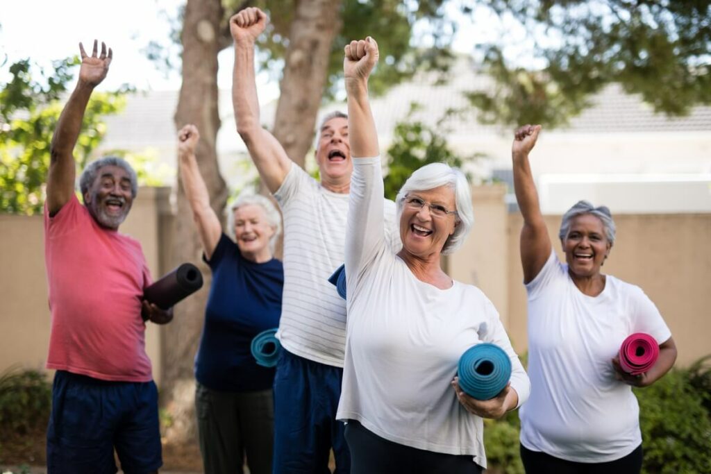 Pegasus Senior Living | Group of seniors holding exercises mats with their fists int he air