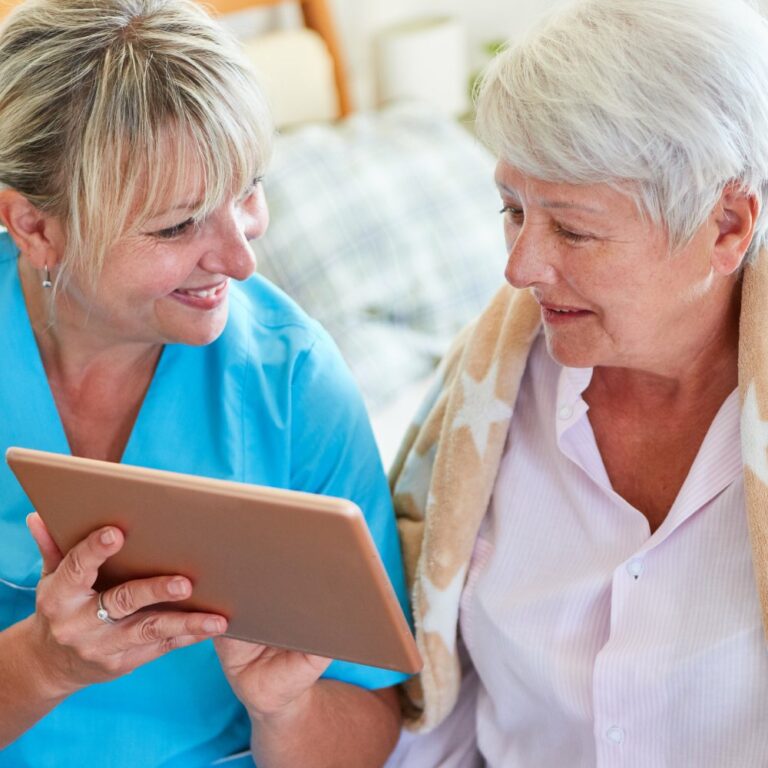 Pegasus Senior Living | Caregiver shows residents a tablet