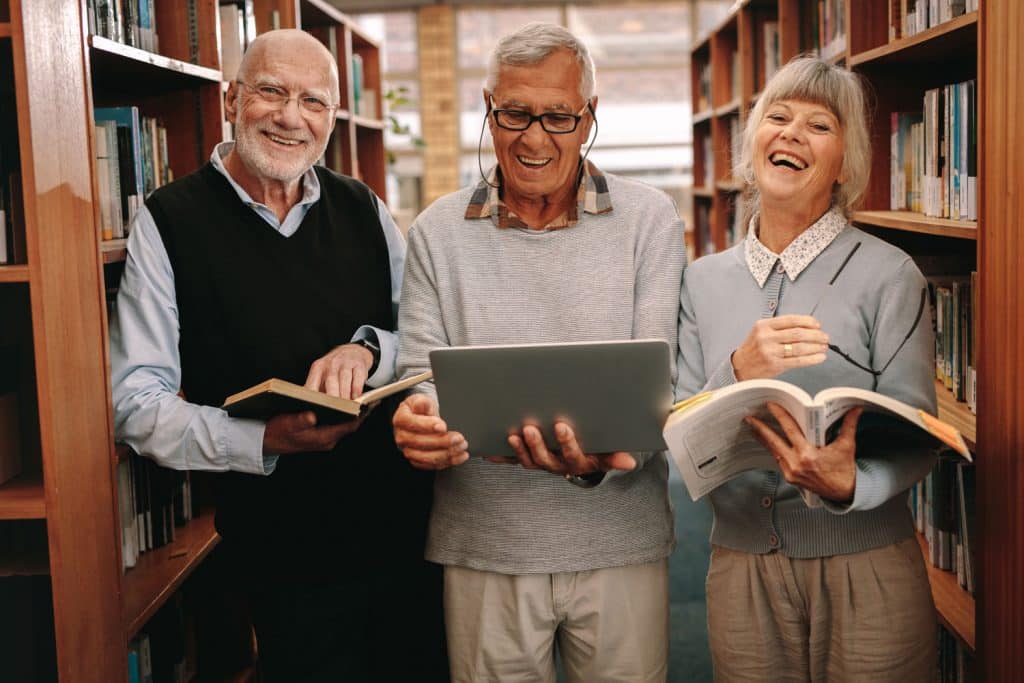 Glenwood Village of Overland Park | Seniors reading books in library
