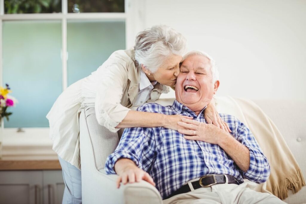 Glenwood Village of Overland Park | Senior woman geving a senior man a kiss on the cheek