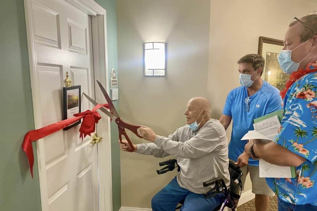 Glenwood Village of Overland Park | Senior cutting ribbon on their new apartment