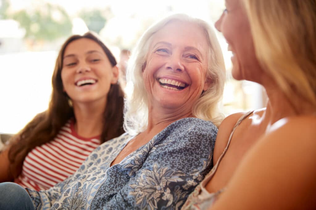 Historic Roswell Place | Senior lady laughing on the sofa with her daughters