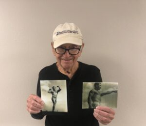 Laketown Village | Mr. Louisiana holding his old bodybuilding photos