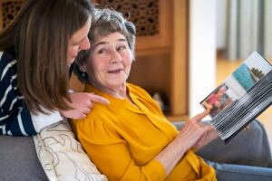 Laketown Village | Senior woman with caregiver looking at photos