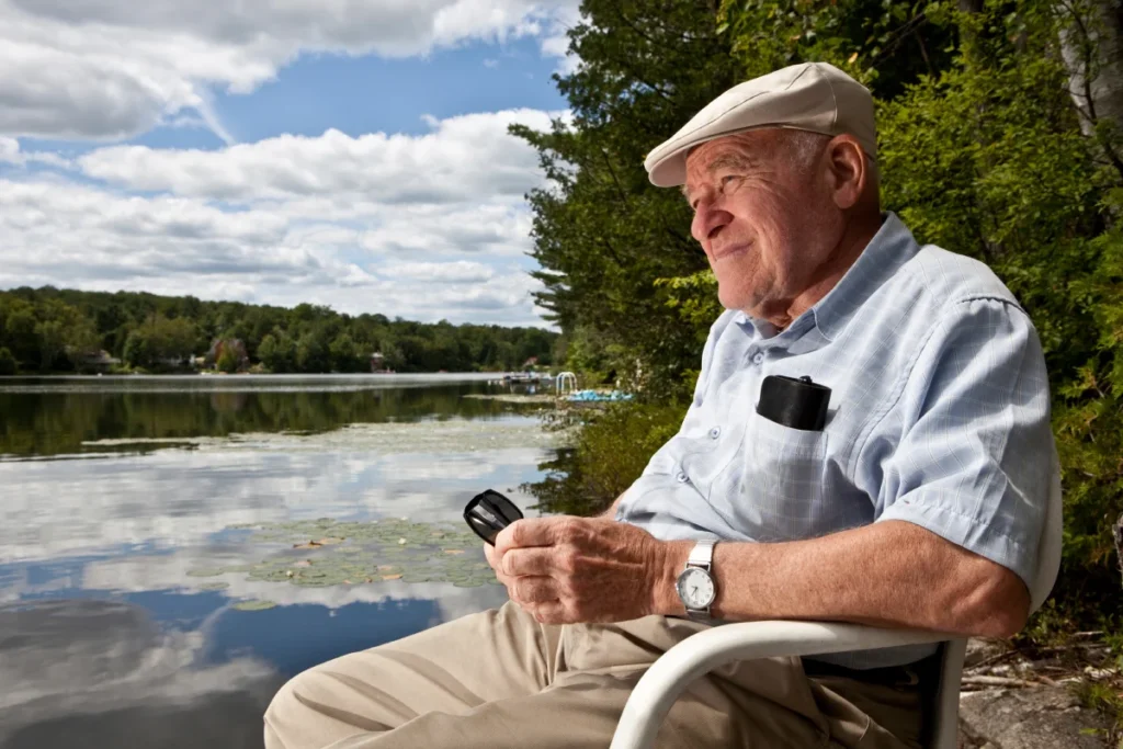 Senior man sitting near a lake
