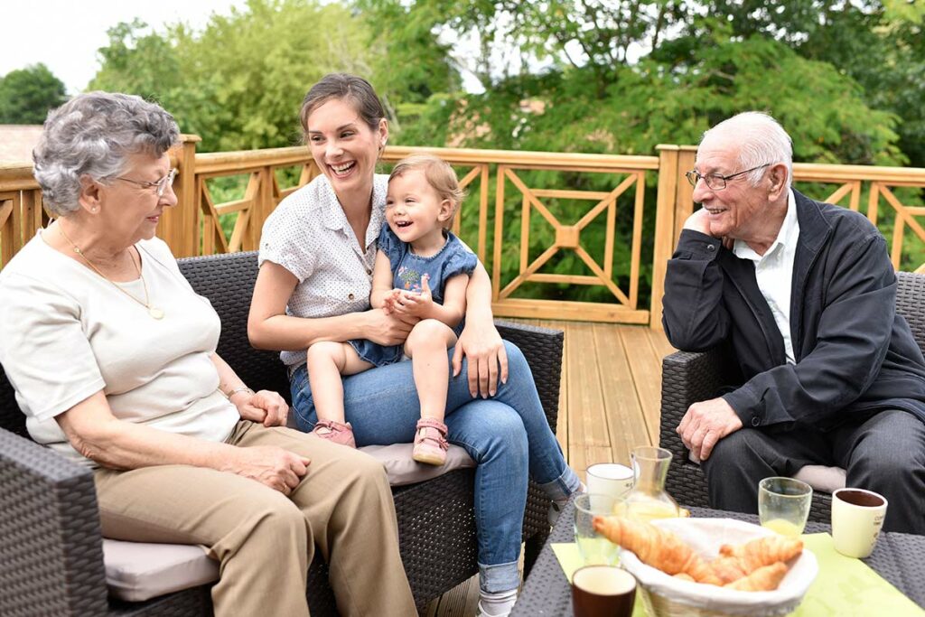 North Point Village | Seniors with family members sitting outside on deck