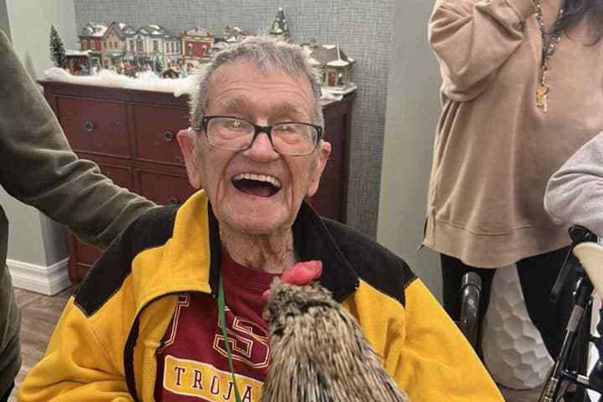 North Point Village | Resident at a memory care facility petting a rooster