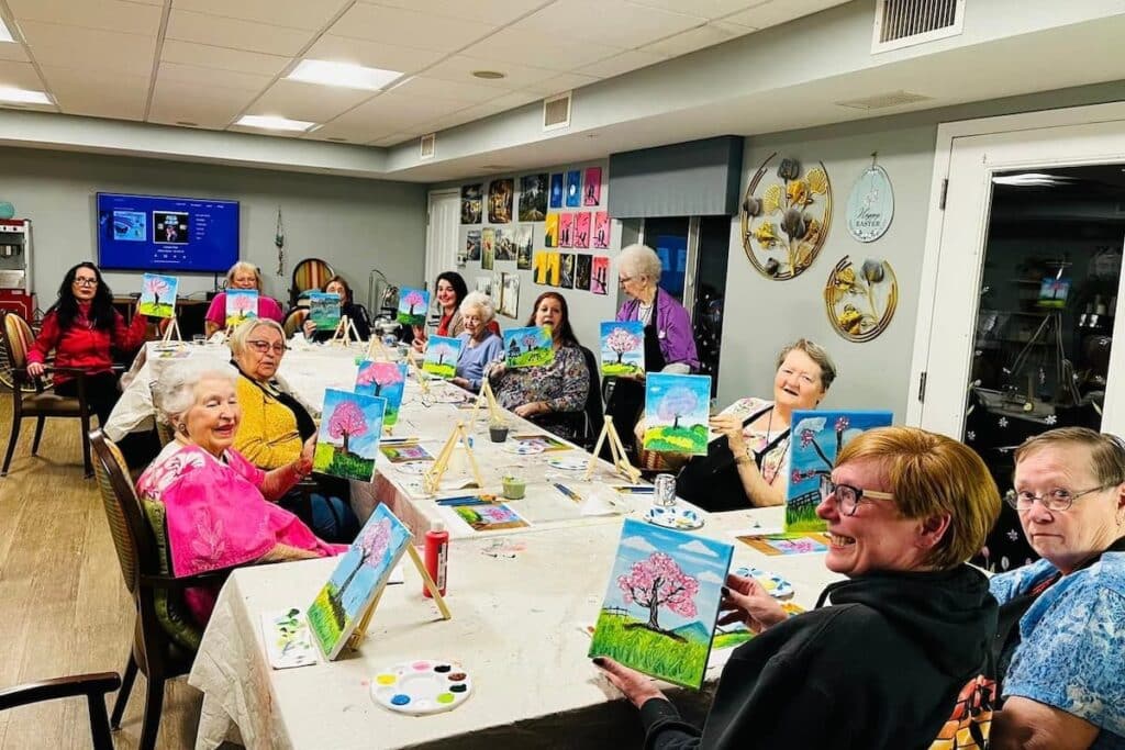 North Point Village | Group of senior community residents holding up their paintings