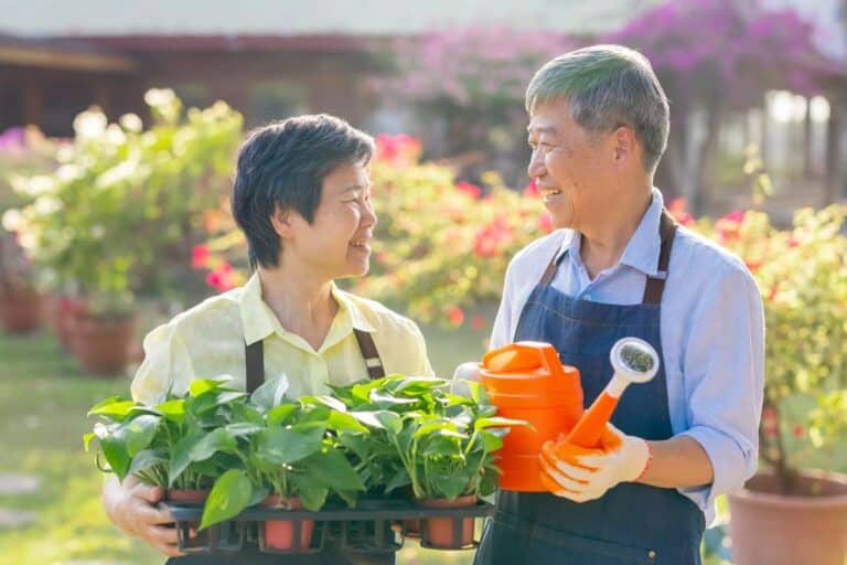 Parmer Woods at North Austin | Senior couple holding gardening equipment