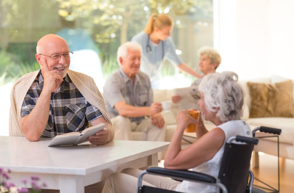 Pegasus Landing of Katy | A senior man sitting at a table holding a book and engaged in conversation with a senior woman