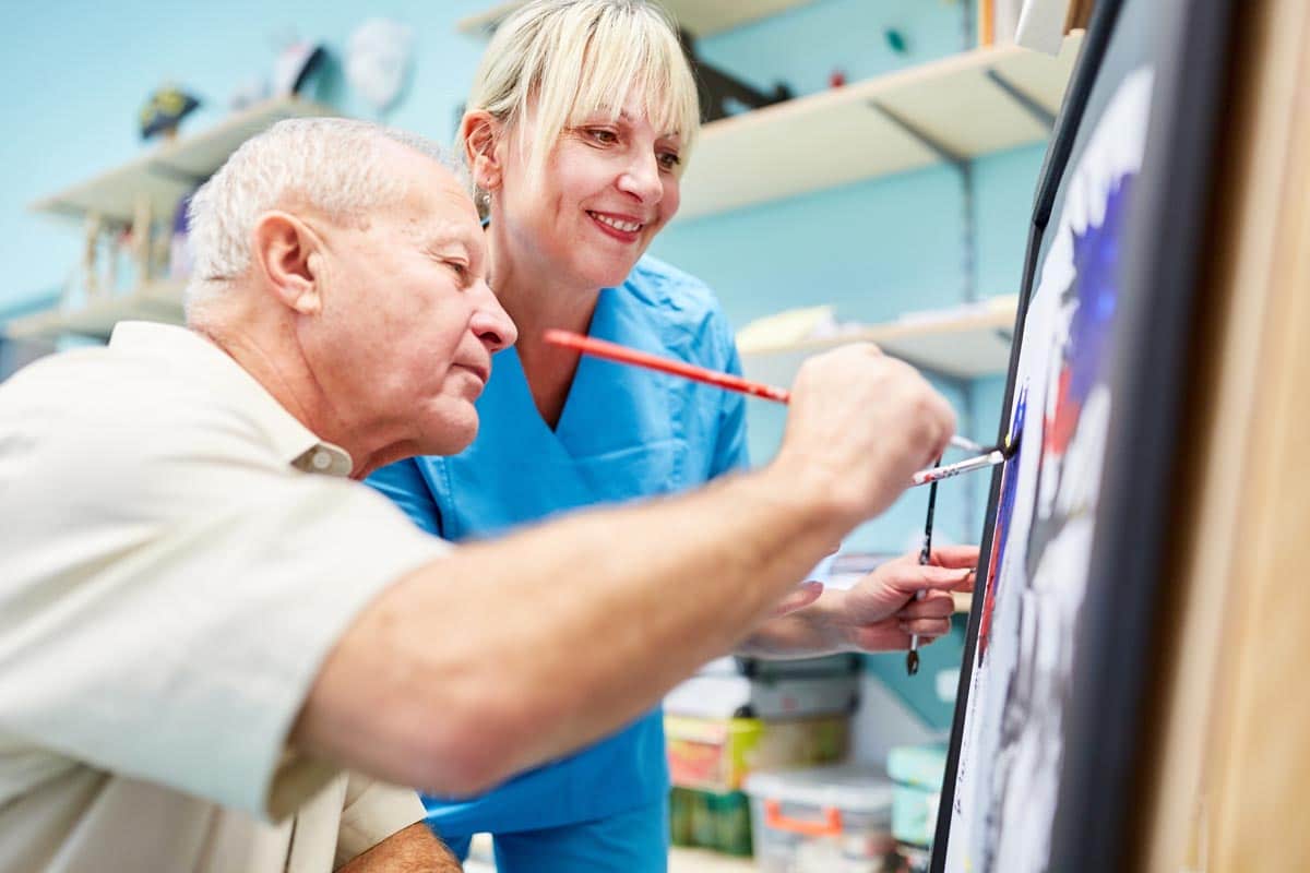 Pegasus Landing of South Plains | Caregiver and man painting