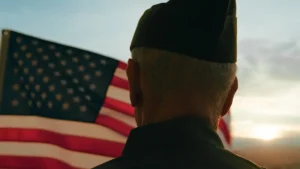 Elderly Man Stand Against American Flag For Veterans Day Holiday.