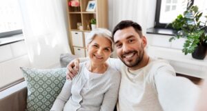 Ridgeland Place | Alzheimer's apartments | happy smiling senior mother with adult son taking selfie at home