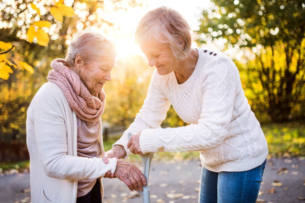 South Hill Village | Woman handing a cane to her aging mother