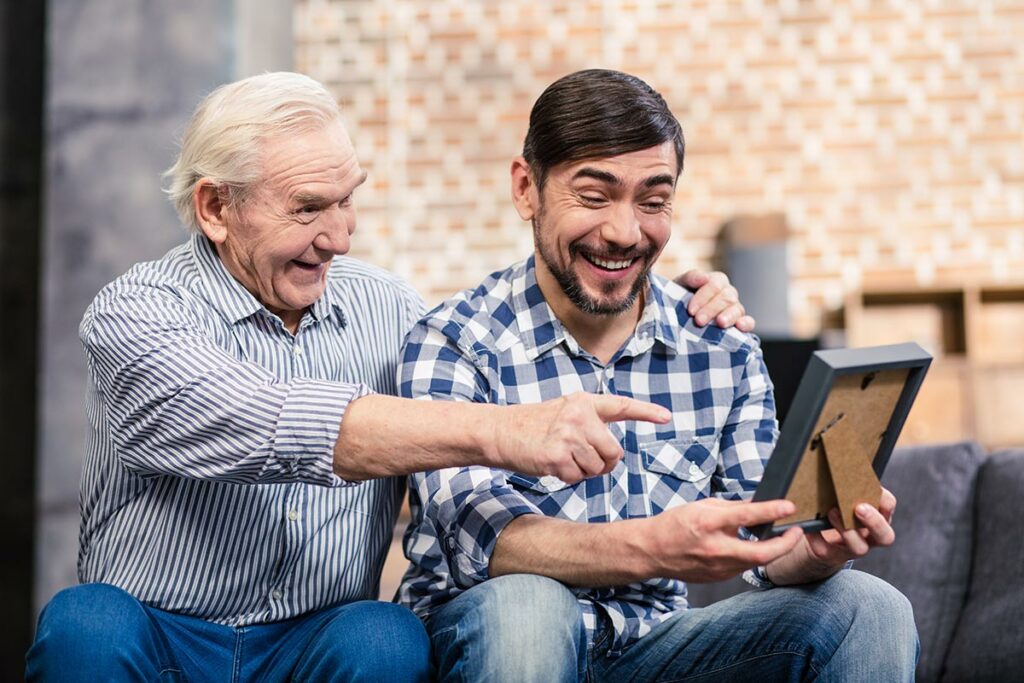 South Hill Village | Senior man and son looking at photo