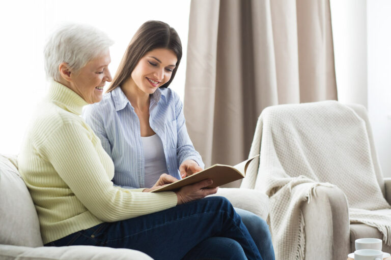 Pegasus Senior Living | Senior reading with associate