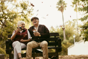 The Chateau at Gardnerville | Senior couple sitting on a bench outdoors, drinking coffee