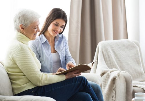 Pegasus Senior Living | Senior reading with associate