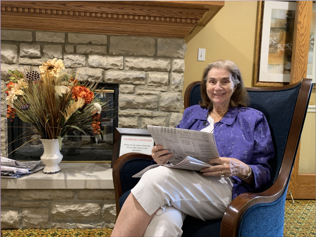 The Courtyards at Mountain View | Resident reading newspaper