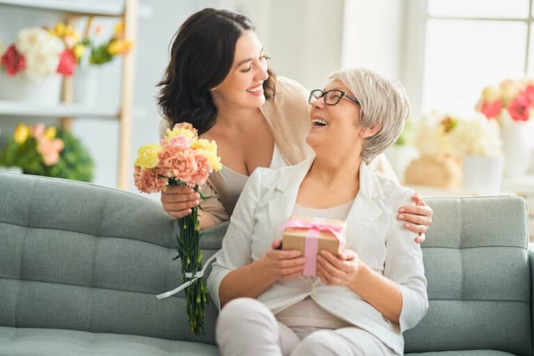 Pegasus Senior Living | Senior womans daughter bring her flowers and a small gift