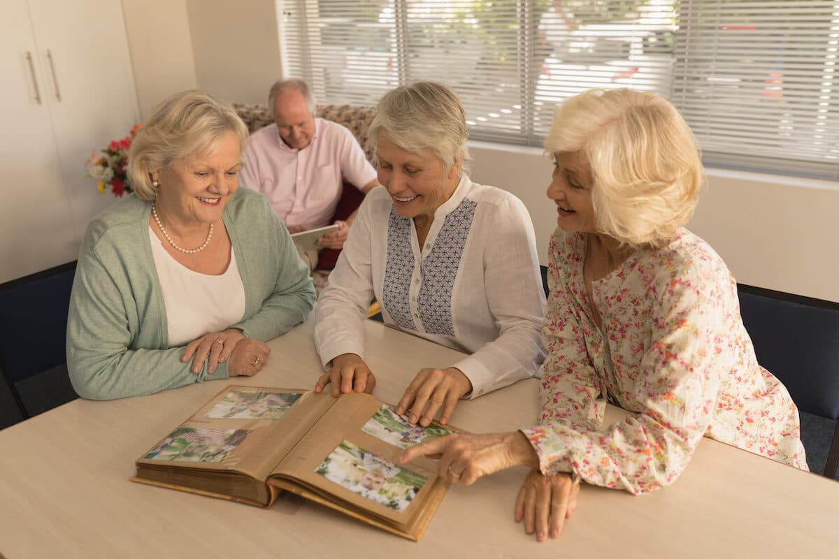 The Courtyards at Mountain View | Senior woman looking through a photo a album together