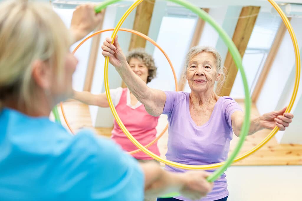 The Courtyards at Mountain View | Seniors doing fitness training with hoops