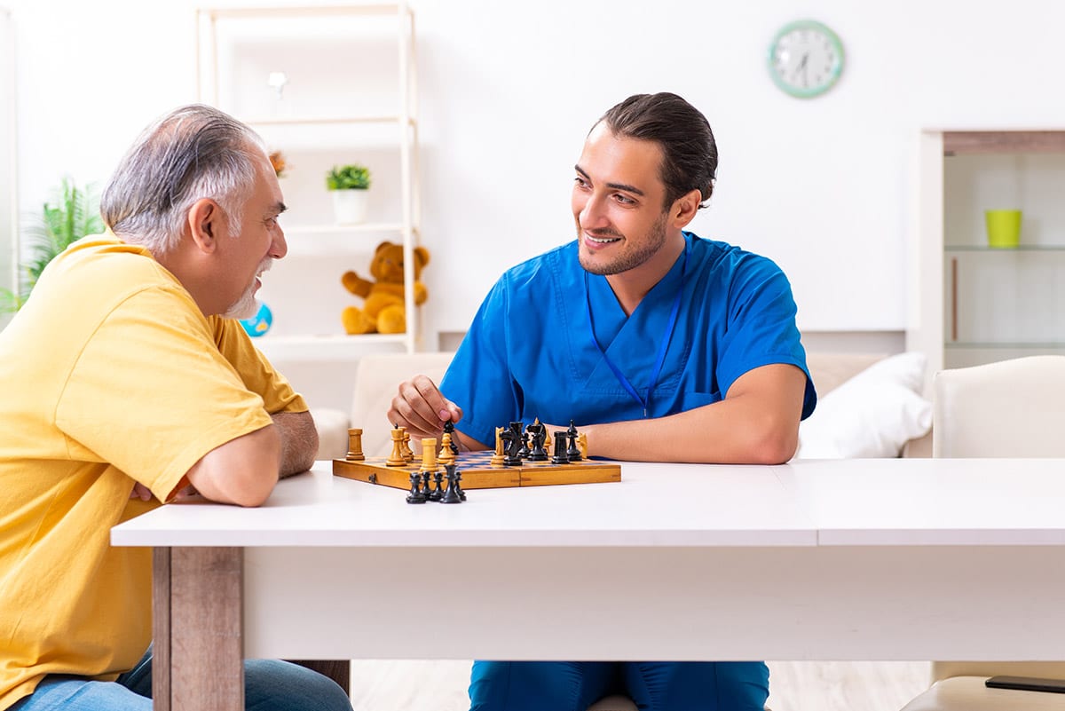 The Courtyards at Mountain View | Young male doctor visiting old patient at home