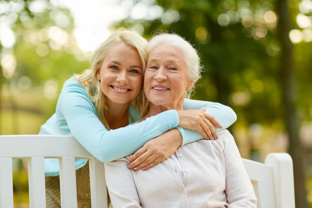 The Farrington at Tanglewood | Senior women and her daughter hugging outside on a bench