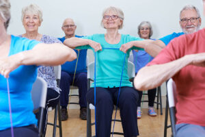 Pegasus Senior Living | Group Of Seniors Using Resistance Bands In Fitness Class