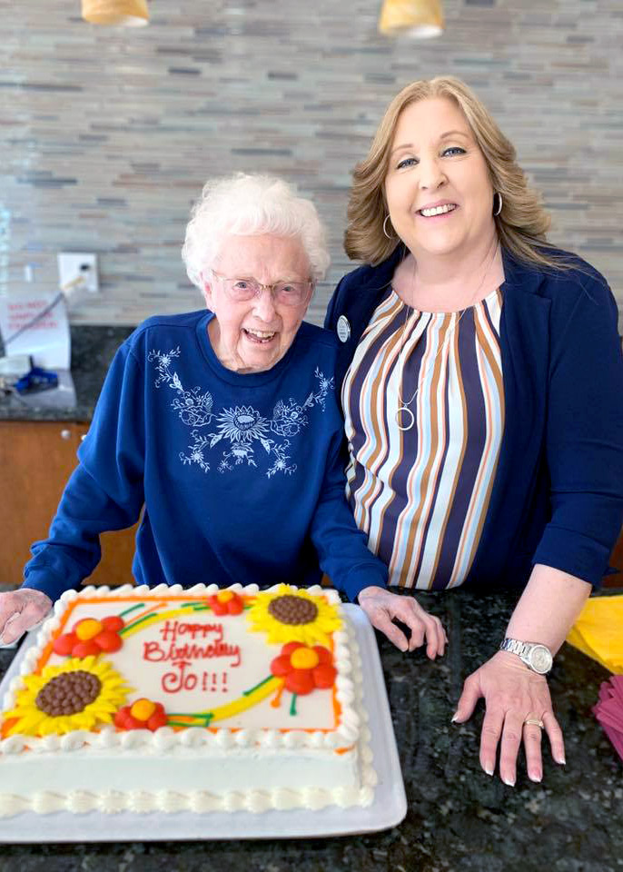 Pegasus Senior Living | Resident and associate with birthday cake