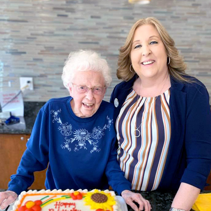 Pegasus Senior Living | Resident and associate with birthday cake