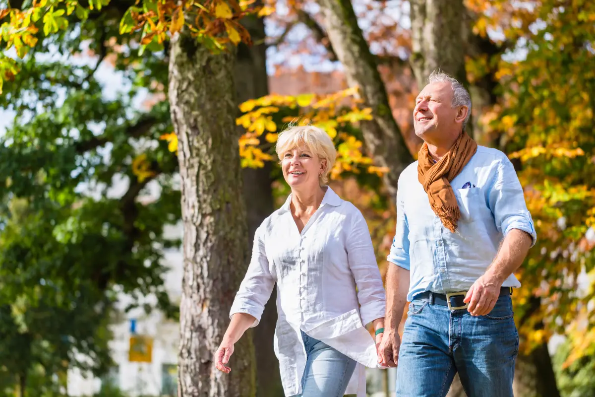 Seniors walking through autumn foliage