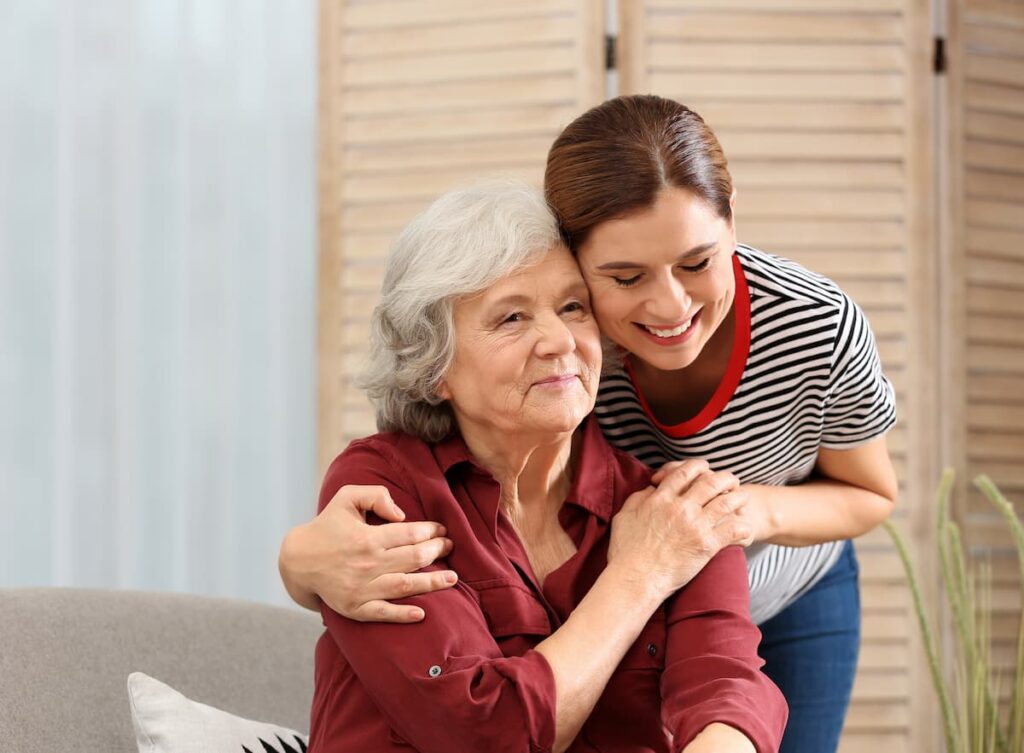 The Legacy at Crystal Falls | Senior embraced by caregiver