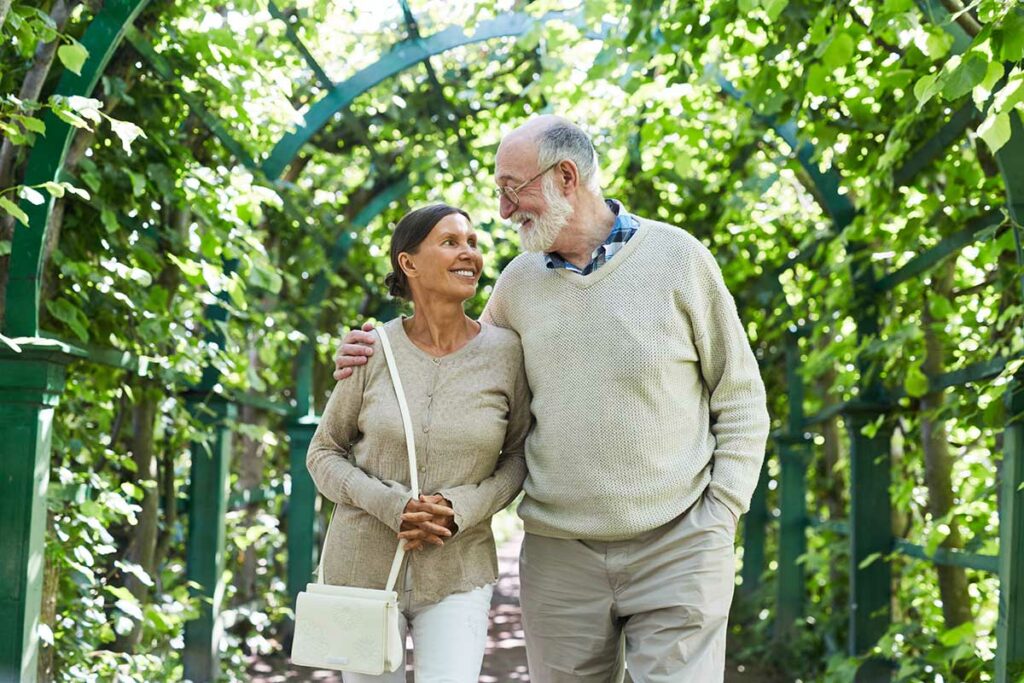 The Oaks at Inglewood | Senior man and woman walking outside under arbor