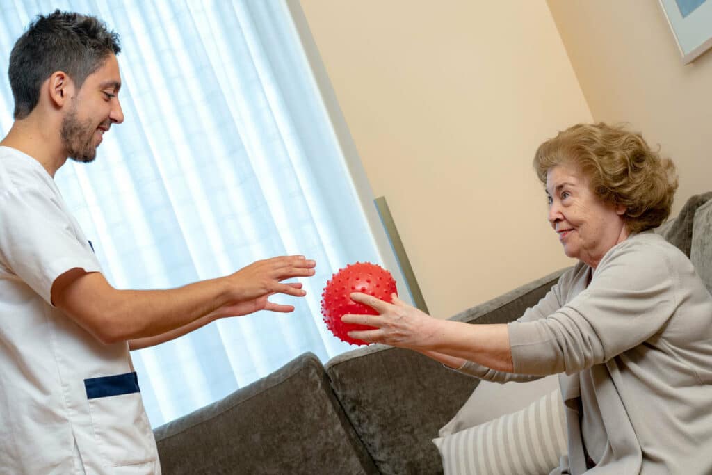 The Village at Rancho Solano | Senior woman and therapist doing coordination exercise with ball