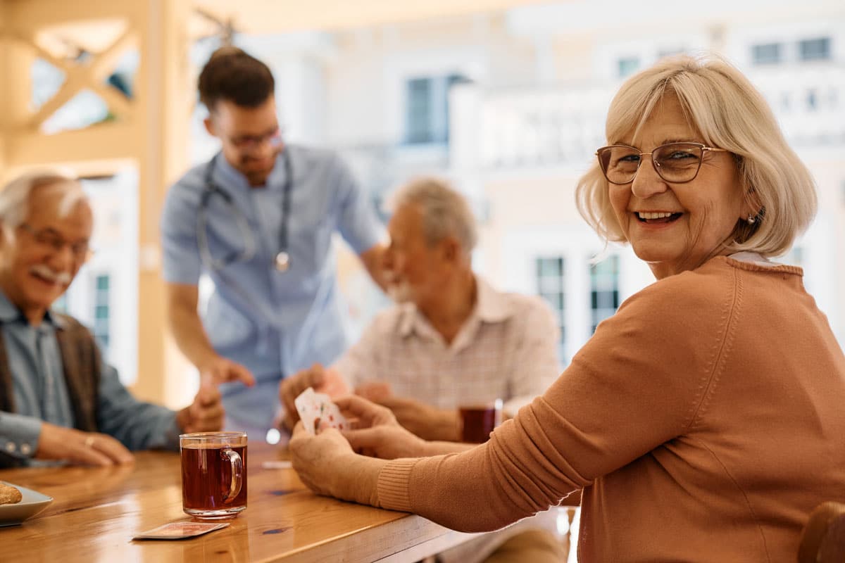 The Village at Rancho Solano | Seniors playing cards and laughing together