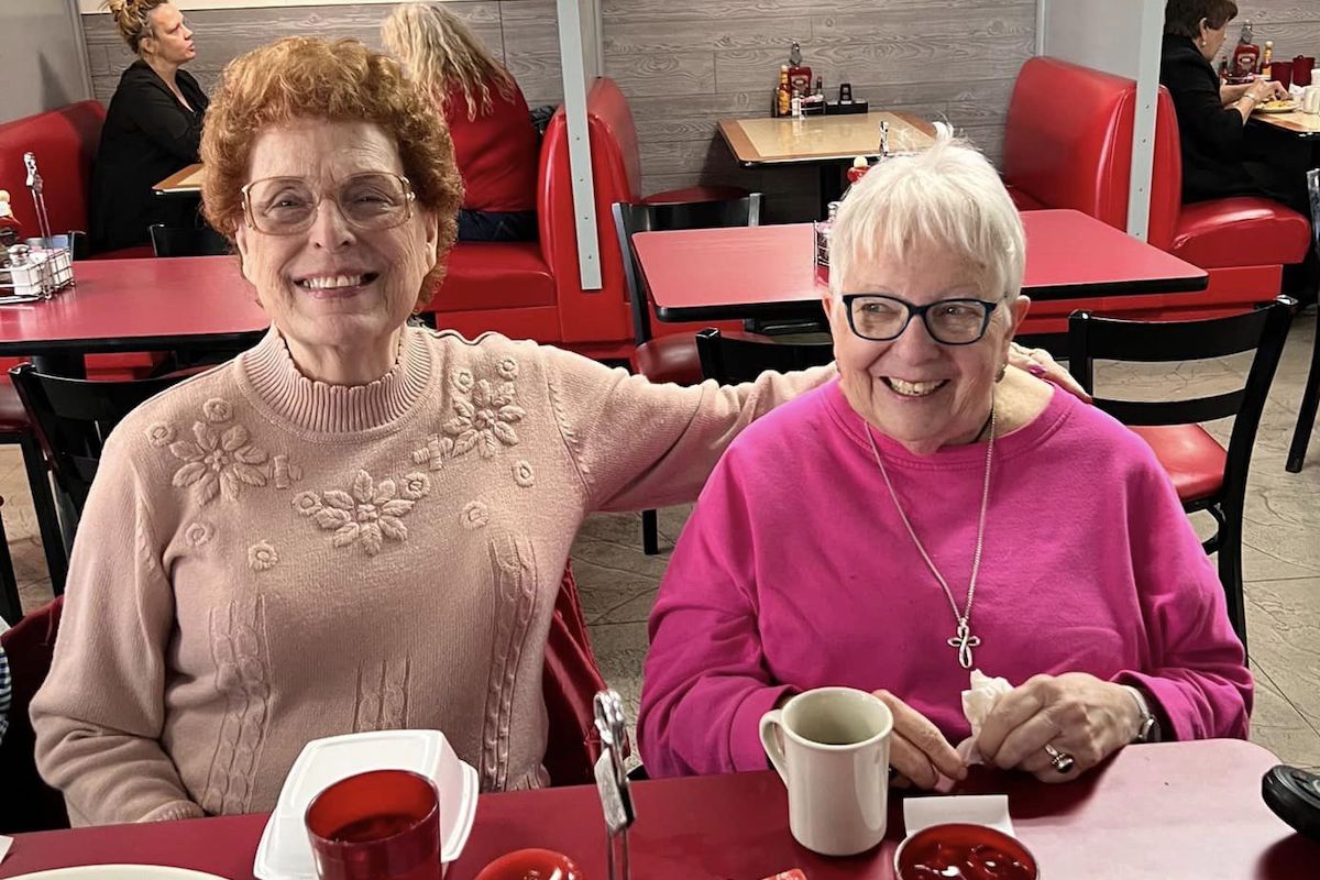 Town Village Crossing | Senior friends laughing at a diner