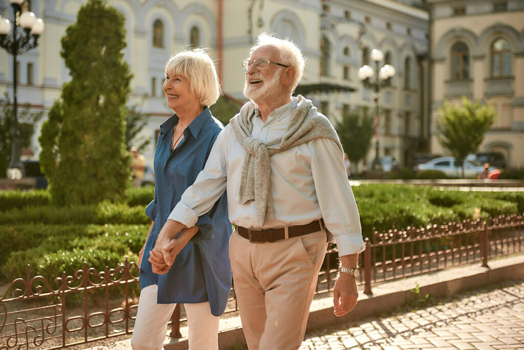 Town Village Crossing | Senior couple walking through town holding hands