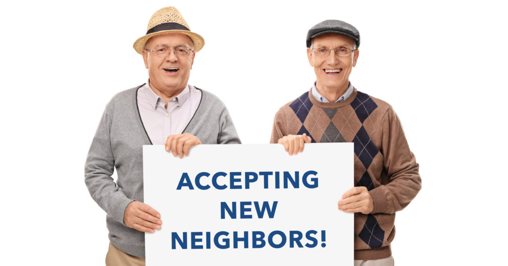 Town Village of Leawood | Senior men holding "Accepting New Neighbors" sign